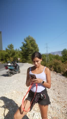 woman using phone by the road