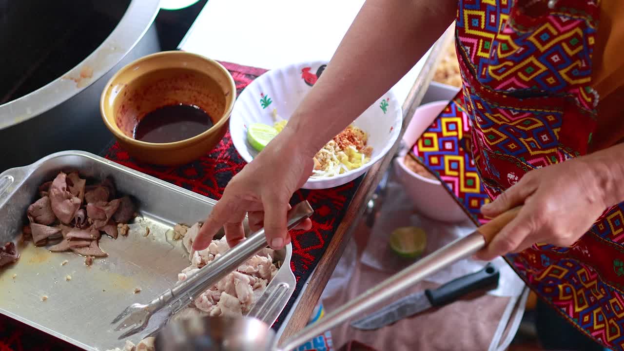 preparando un plato de fideos en el mercado flotante de bangkok