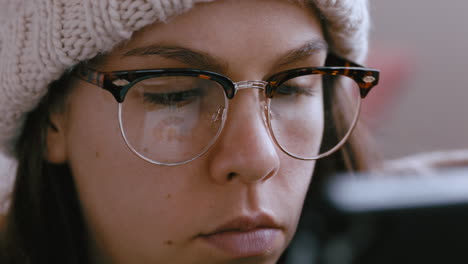 close up portrait beautiful woman using tablet computer browsing digital documents online on mobile touchscreen device relaxing at home wearing glasses