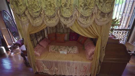 a bedroom in pinang peranakan mansion in penang, malaysia with an antique dressing table with mirror and a study table with small bed in the middle - panoramic shot