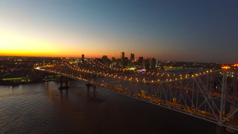beautiful rising night aerial shot of the crescent city bridge over the mississippi river revealing the new orleans louisiana skyline