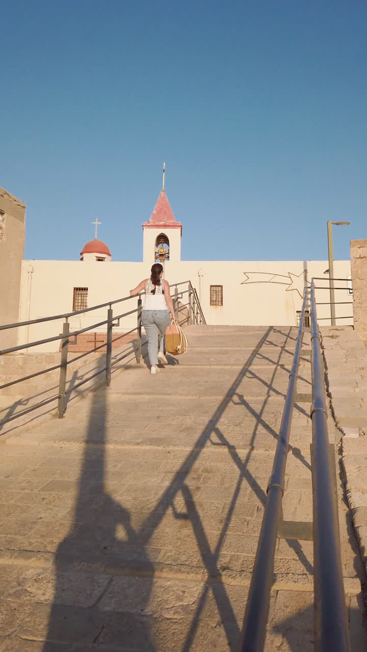 Tourist walking up stone steps in Acre, Israel, old city