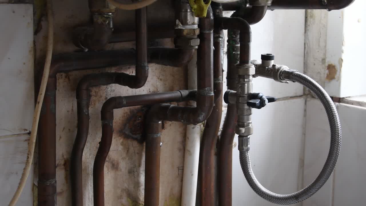 primer plano de tuberías de agua de cobre en una cocina