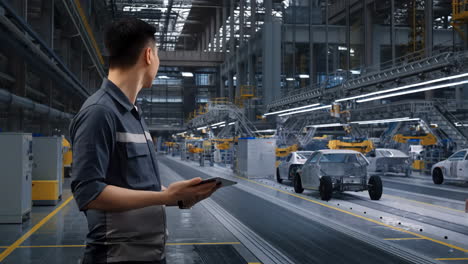 man using a tablet in an automotive manufacturing plant