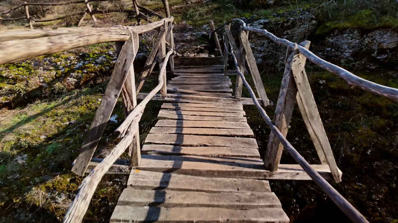 POV crossing an aged insecure wooden hike trail footbridge