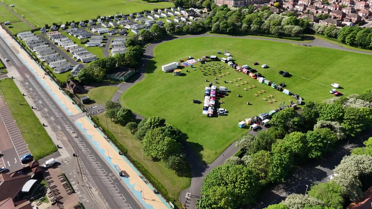 Vista drone di un mercatino delle pulci all'aperto in un campo verde.