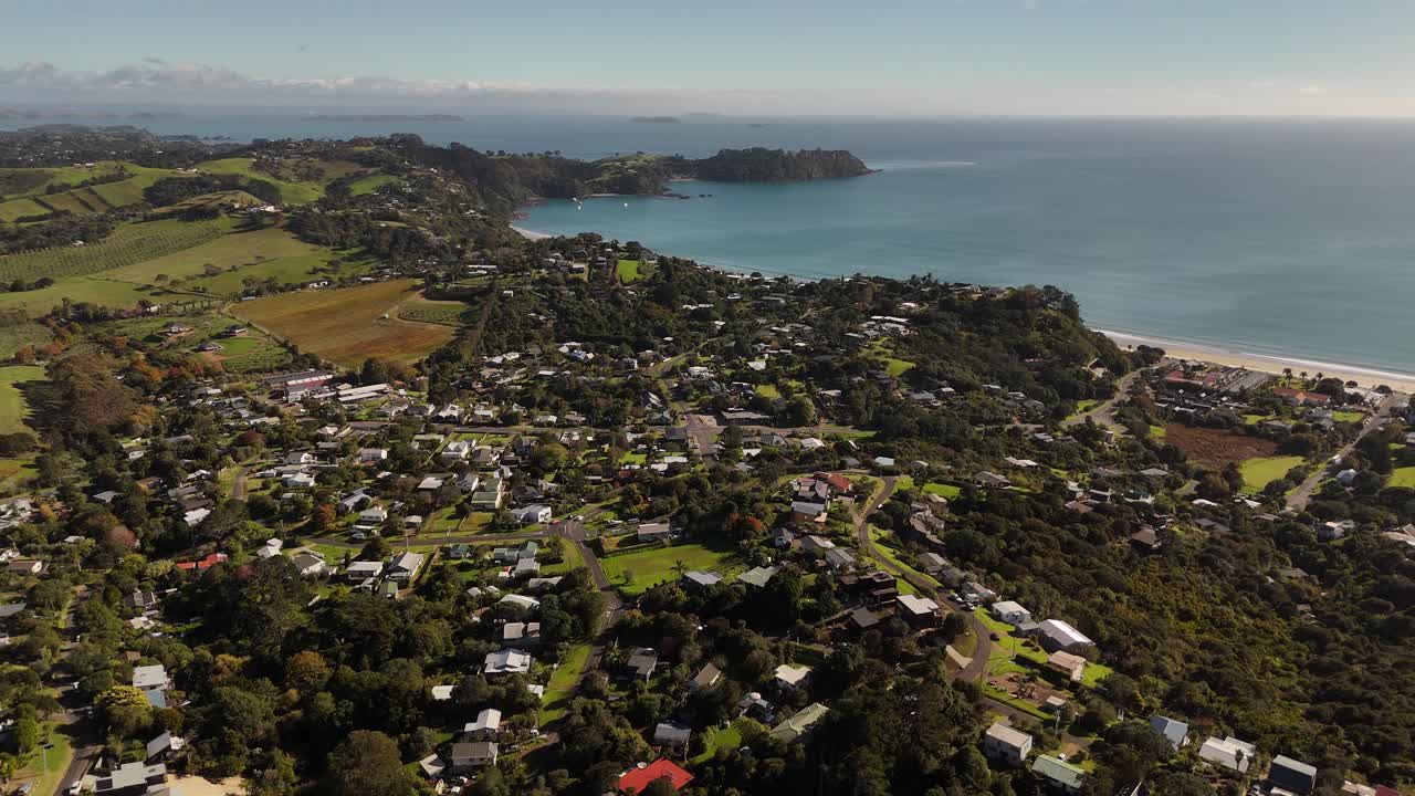 Residential area in Onetangui Area of waiheke Island, neu Zealand. Aerial view. Quiet sunset time with farm fields in rural area. Houses and home with ocean bay view