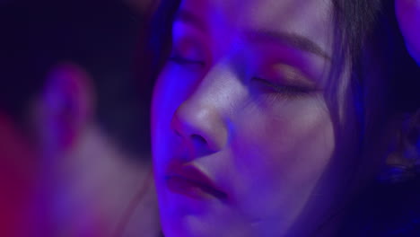 asiatic-attractive-young-female-model-woman-close-eyes-and-resting-with-blue-led-light-in-her-face