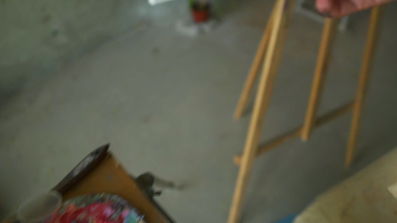 Artist mixes pink paint on the palette before painting a picture, painter at the studio, creator makes piece of art. Top view of woman's hand with wide brush applying oil paint on canvas