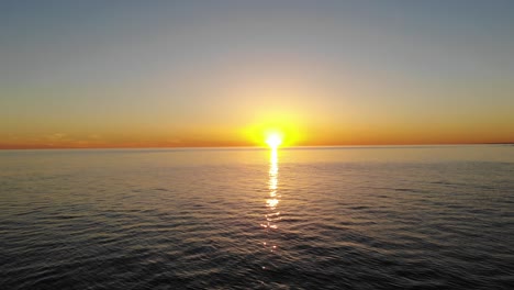 panning cinematic aerial drone flying low over ocean overlooking sunset