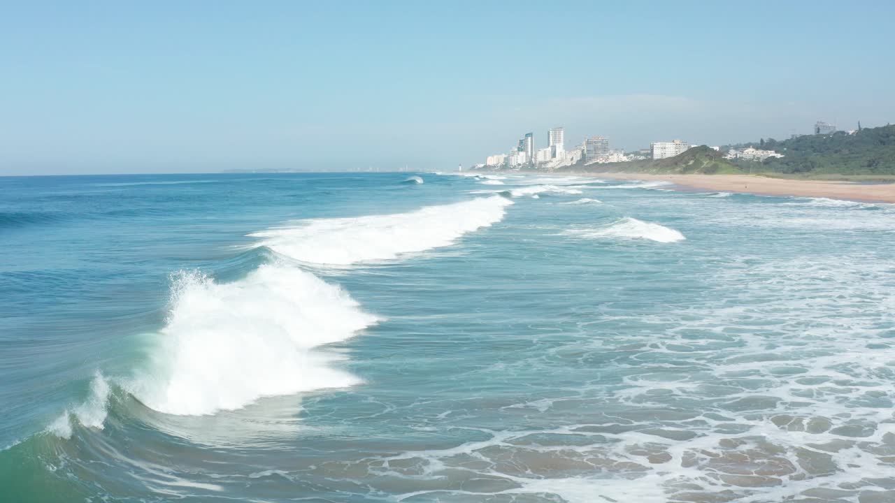 Closeup aerial waves breaking along blue Indian Ocean shoreline Durban