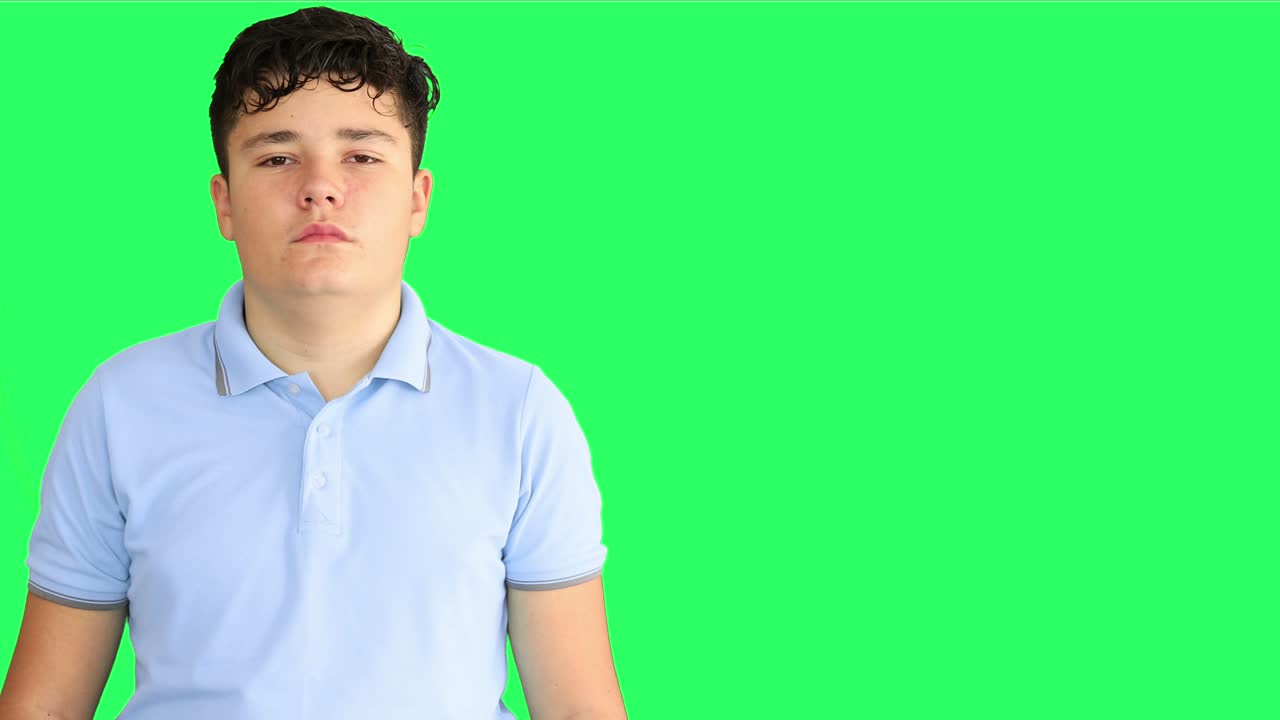 niño adolescente con cara seria en el fondo de la pantalla verde