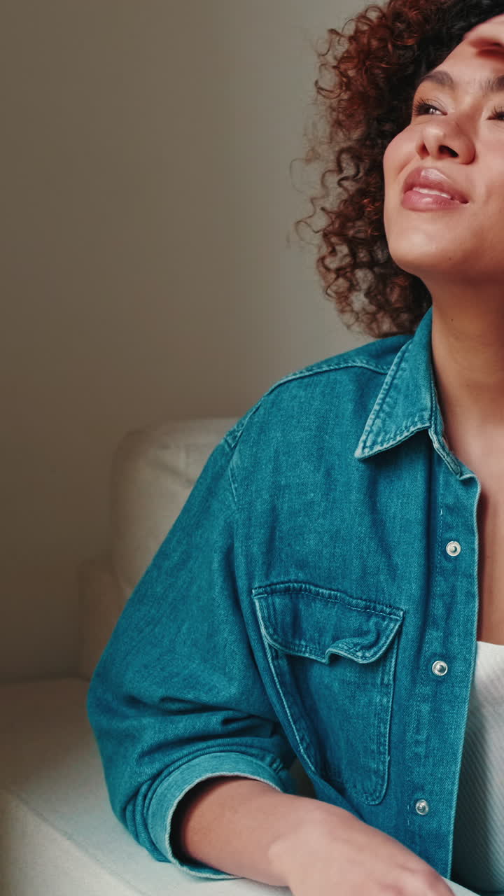 Happy Young Woman with Curly Hair Smiling and Looking Up