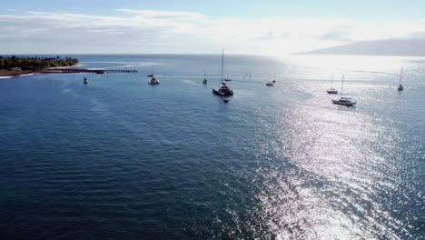 Aerial-panoramic-view-of-boats-in-ocean-revealing-Hawaiian-shoreline