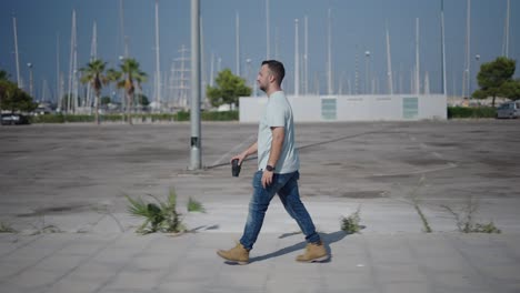 man walking in a city parking lot by the marina