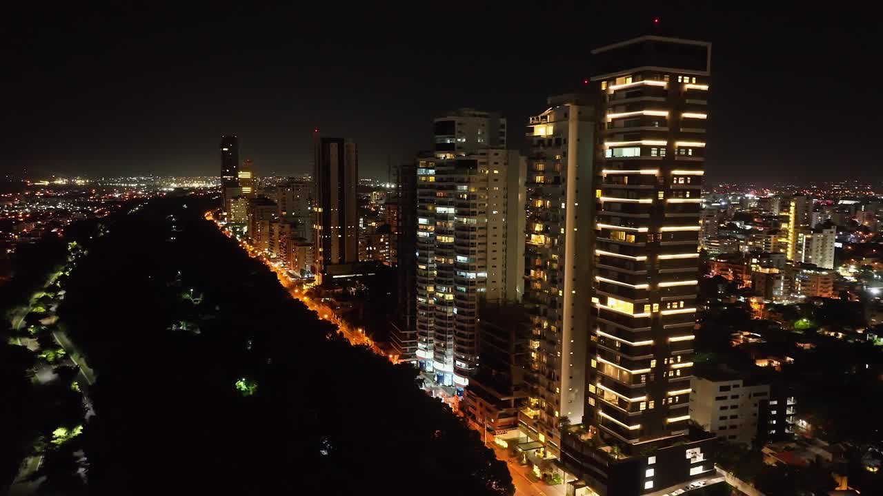 rascacielos y edificios de lujo iluminados a lo largo de la avenida anacaona en la ciudad de santo domingo por la noche, república dominicana