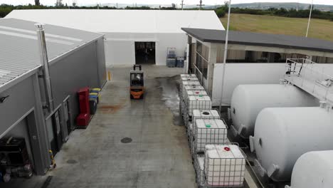 máquina de elevación de horquilla que transporta una carga a través del área industrial hasta el almacén