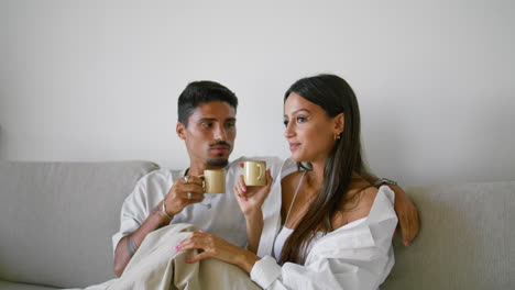 romantic couple watching movie at home closeup. loving family enjoying coffee