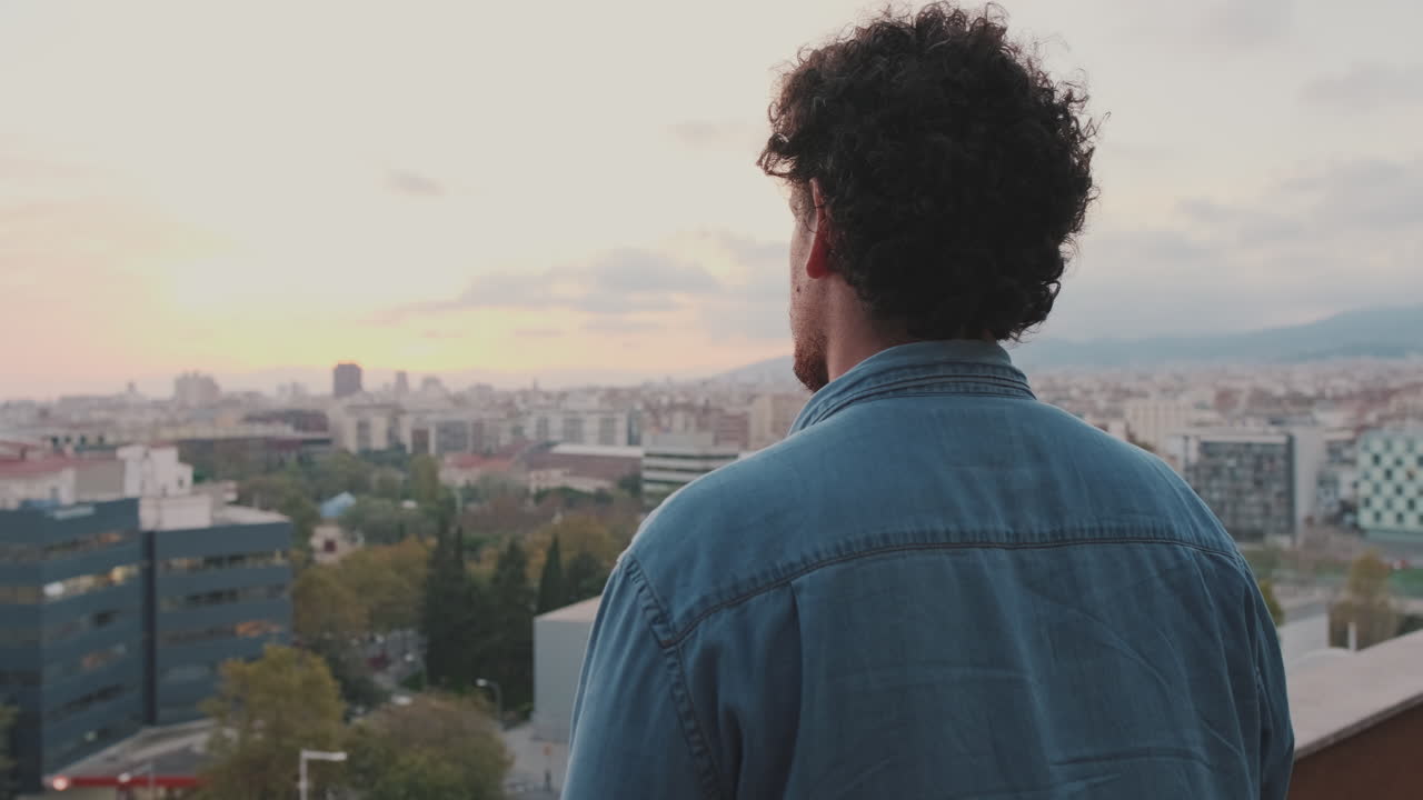 Homem contemplando o horizonte da cidade ao pôr do sol