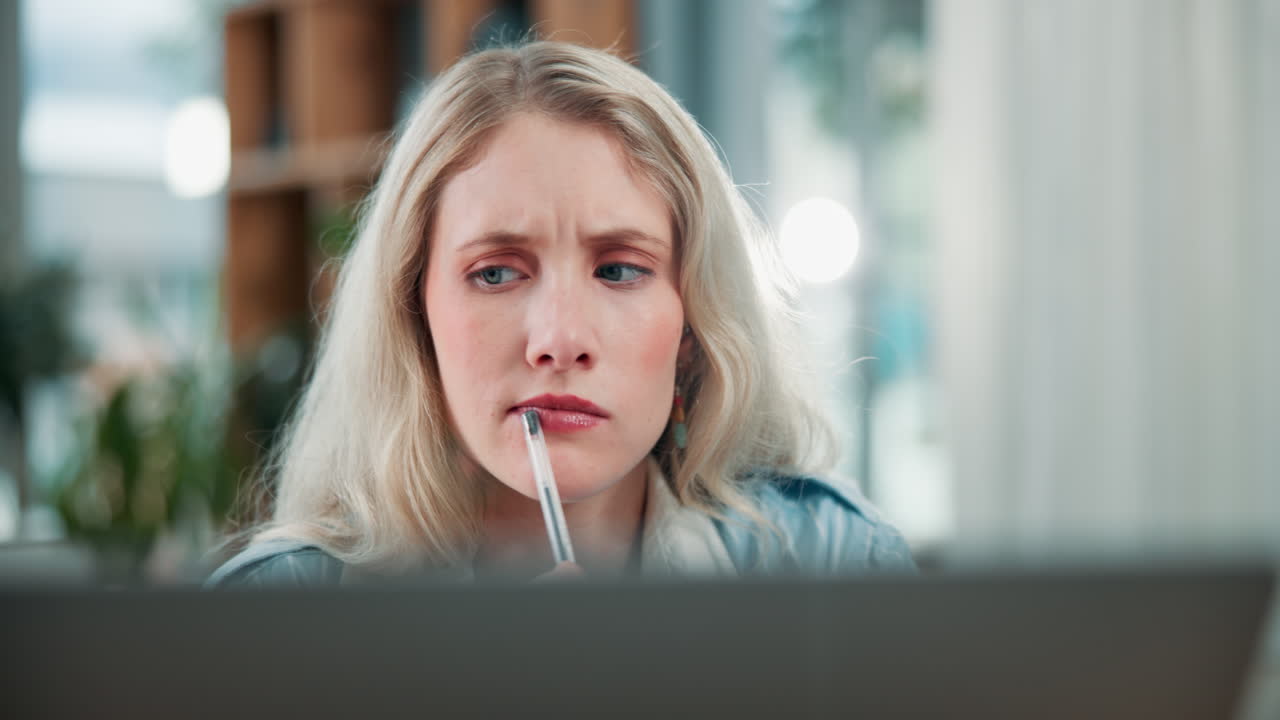 Donna pensierosa con una penna in ufficio