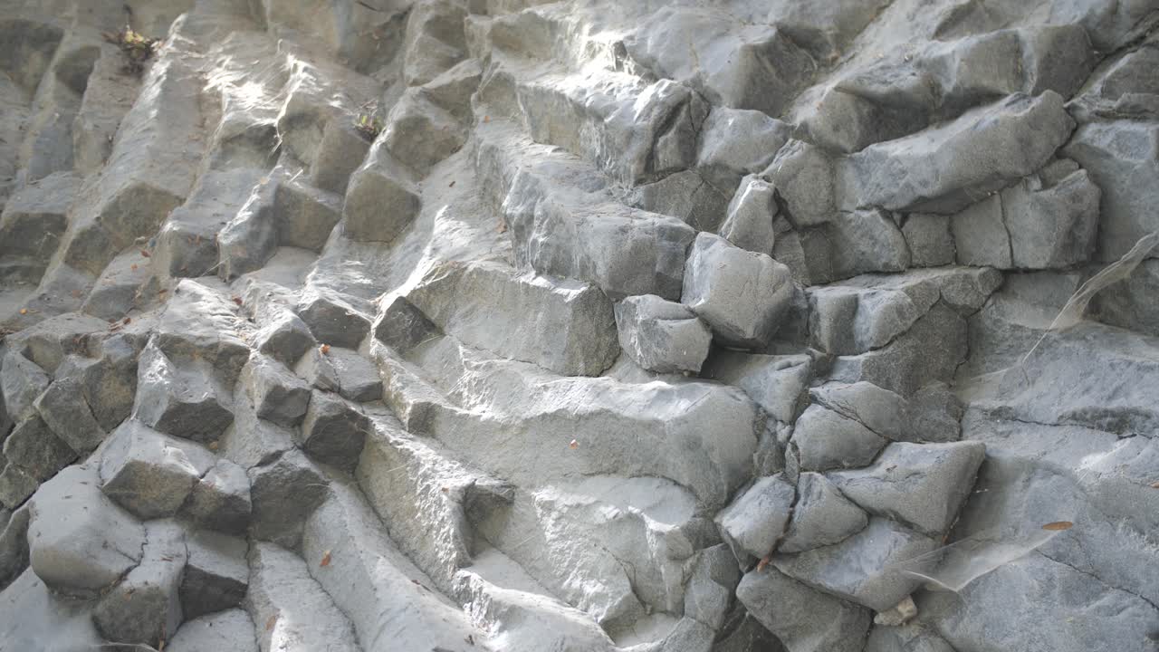 cámara se mueve hacia abajo, decoradas piedras grises y el área alrededor de ellos durante el día en taormina