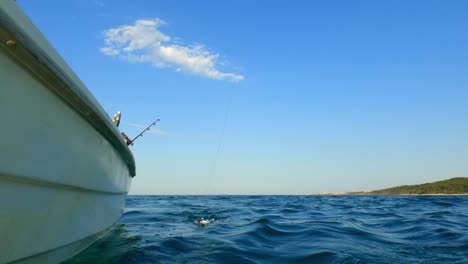 inusual y único punto de vista fuera de borda de ángulo bajo de un pescador capturando peces desde un barco