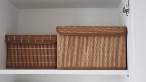 white cabinet with brown storage boxes