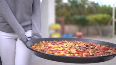 llevando paella a una reunión de personas celebrando