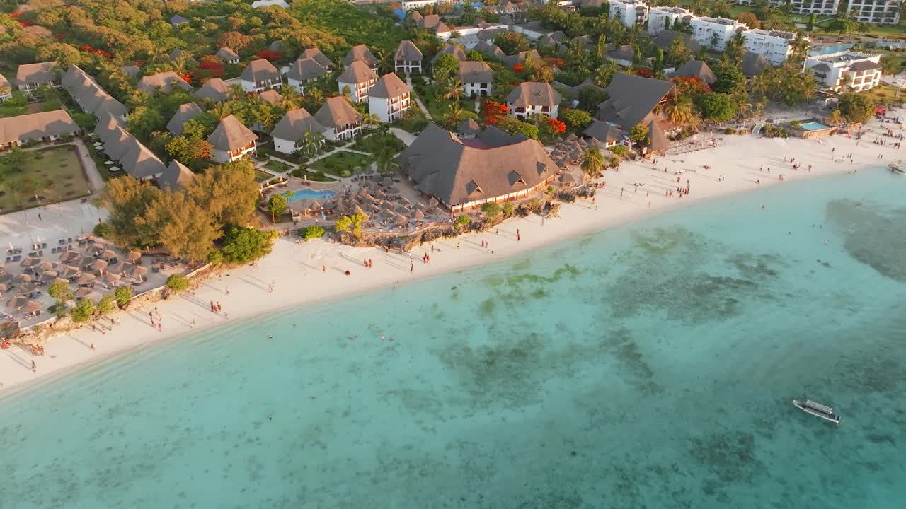Zanzibar’da gün batımında Nungwi Plajı boyunca yapılan sinematik drone uçuşu. Altın rengi ışık, sakin okyanus ve tropikal sahil şeridi; seyahat ve turizm projeleri için ideal, huzurlu ve nefes kesen bir kıyı sahnesi oluşturuyor