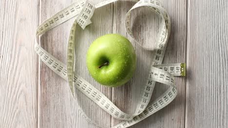 Green-apple-and-measuring-tape-on-table