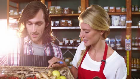 Male-staff-holding-basket-of-vegetables-and-female-staff-with-clipboard