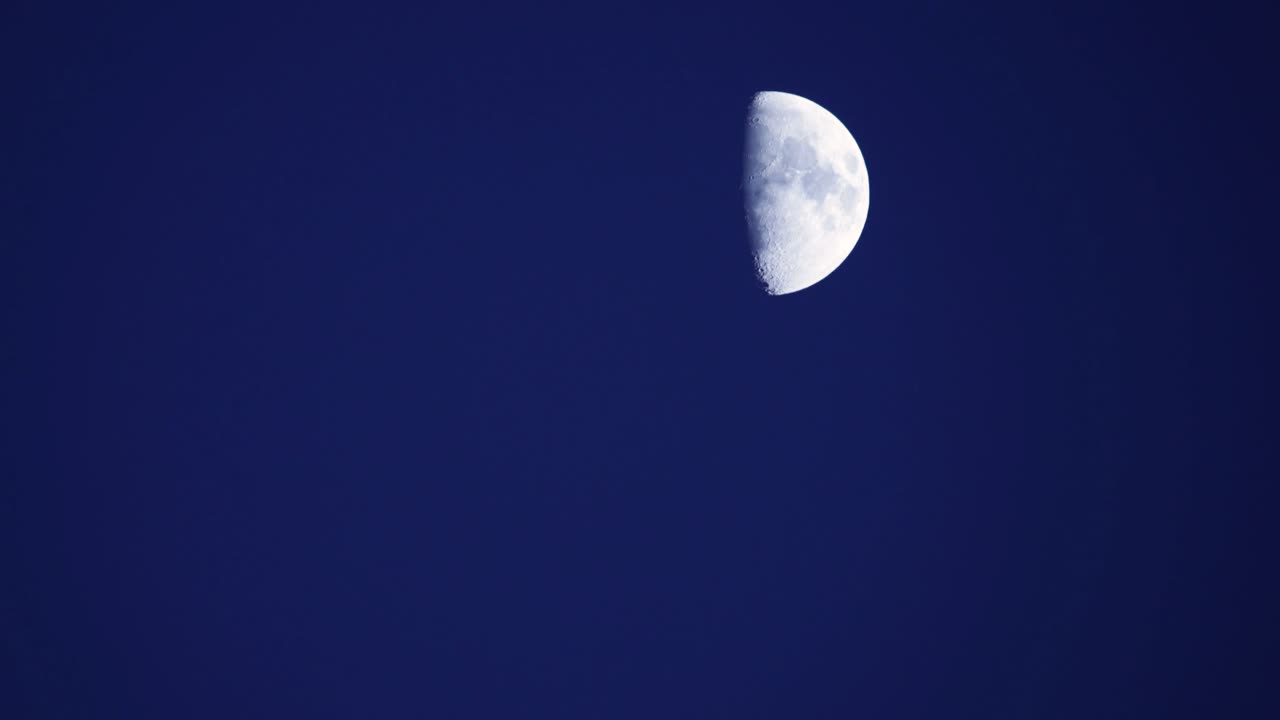 un lapso de tiempo de la luna cruzando el azul pálido del cielo de la tarde
