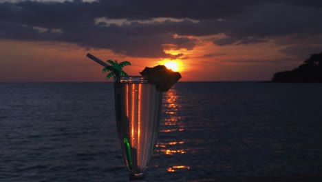 sliding shot of a cocktail at a beautiful sunset