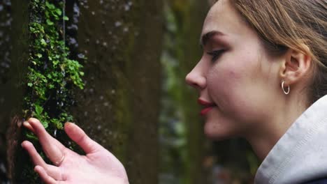 bella joven tocando suavemente las plantas y disfrutando de la naturaleza