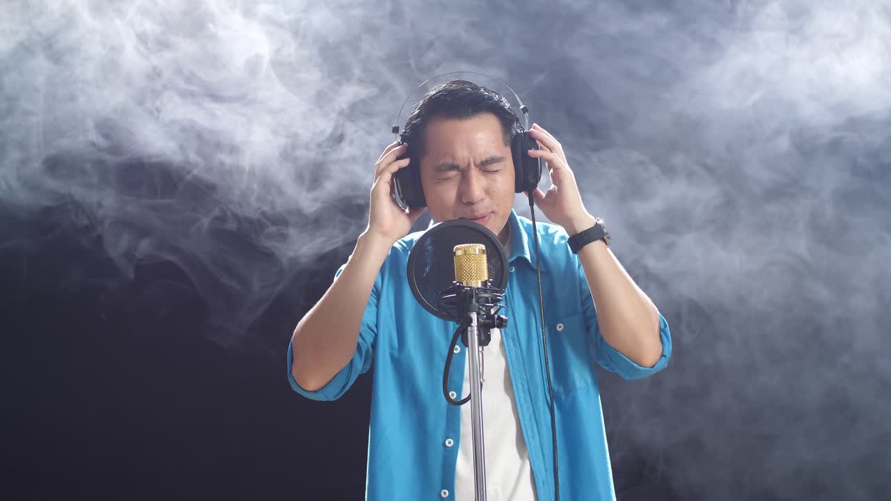 녹음 스튜디오 에서 마이크 로 노래 하는 남자