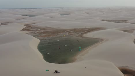 Aerial:-Kitesurfing-in-the-dunes-of-Lencois-Maranhenses,-Northern-Brazil