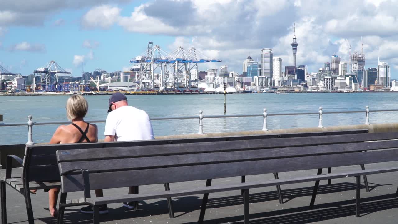 Couple Relaxing on a Bench with Auckland City Skyline in the Background