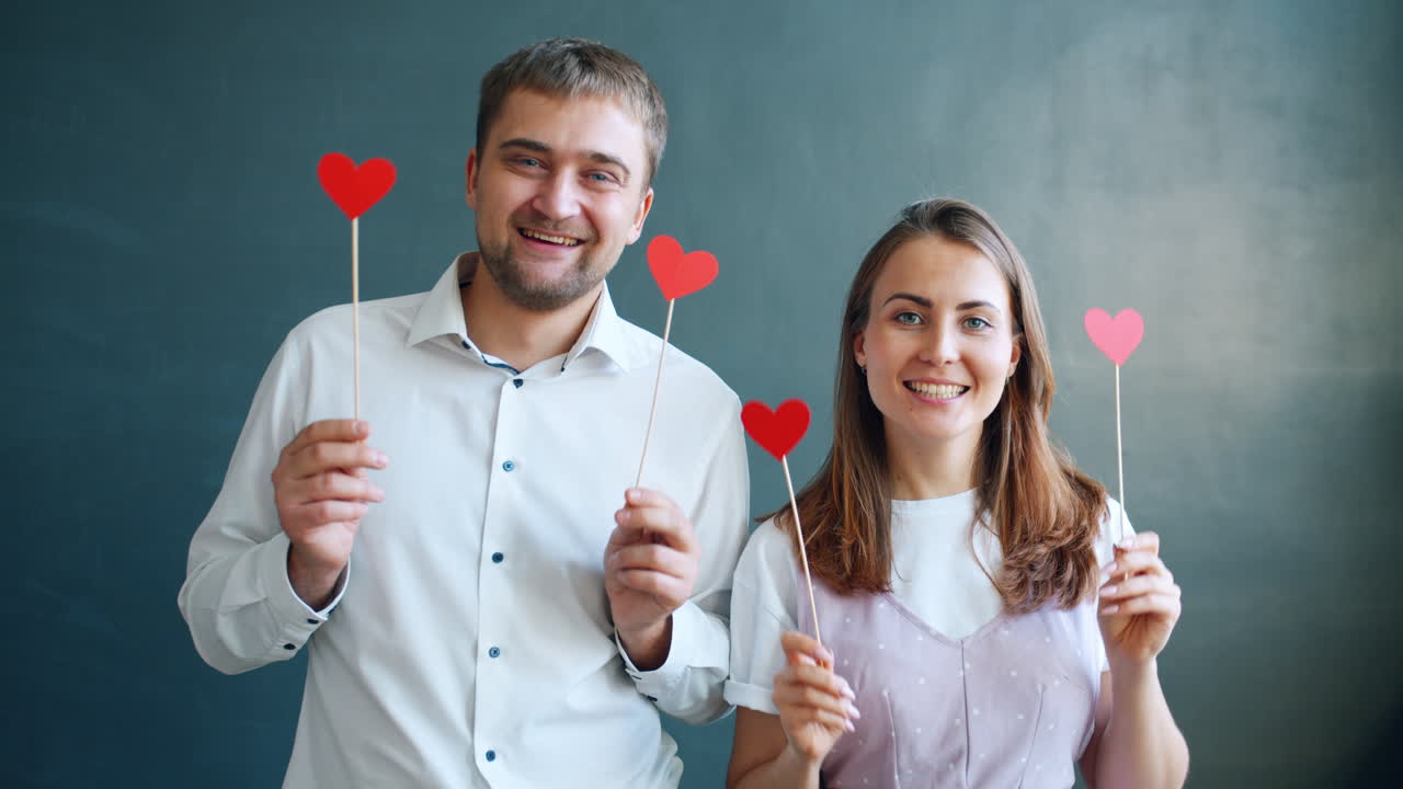 Happy Couple Holding Red Paper Hearts