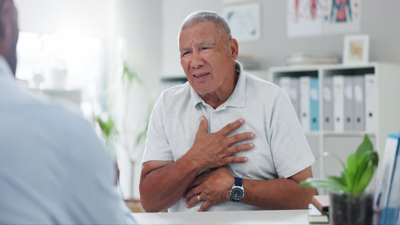 hombre anciano que experimenta dolor en el pecho durante la consulta médica