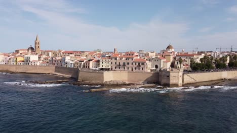 beatiful drone clip of the traditional town of alghero in sardinia, italy with the walls and a cathedral in the background