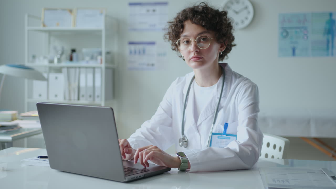 Portrait of Young Female Doctor Working on Laptop in Medical Office