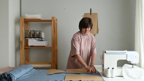 seamstress making clothes pattern in workshop