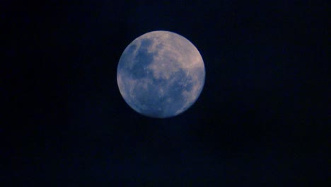 Wolken-Ziehen-Vor-Einem-Vollmond-Vorbei-Und-Schaffen-Eine-Unheimliche-Perspektive