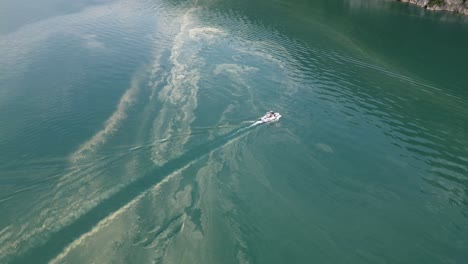 Speed-boat-cutting-through-coral-spawning,destroying-nature-in-lake-water