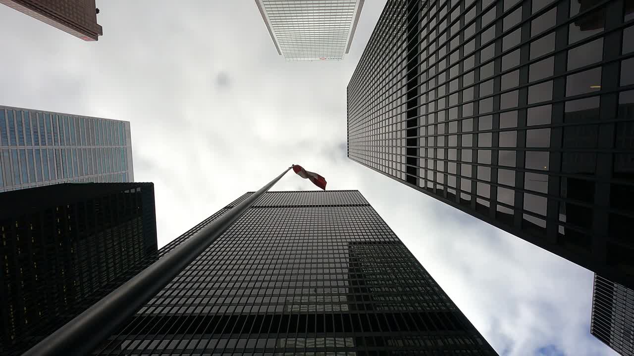 Canada Flag Waving In Wind Surrounded With High-rise Skyscrapers, Toronto, Canada