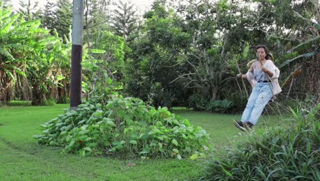 beautiful girl swinging next to tropaeolum bush