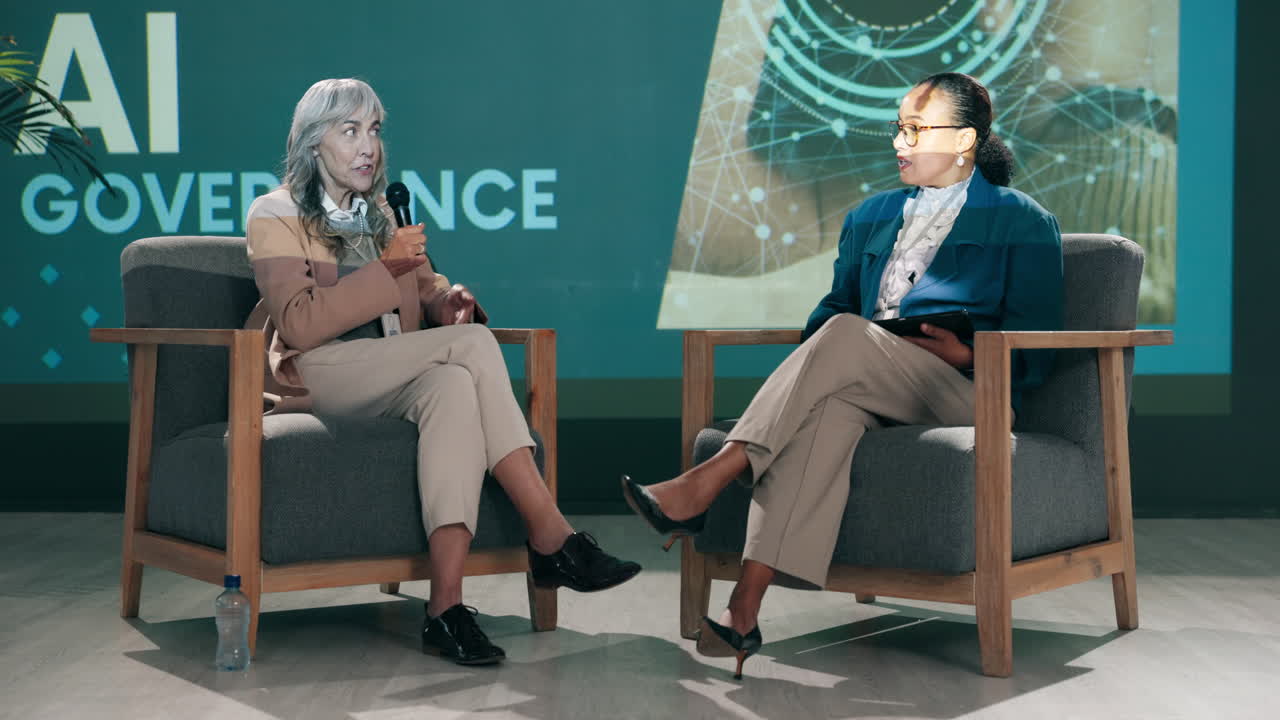 Two women discussing AI governance during a conference