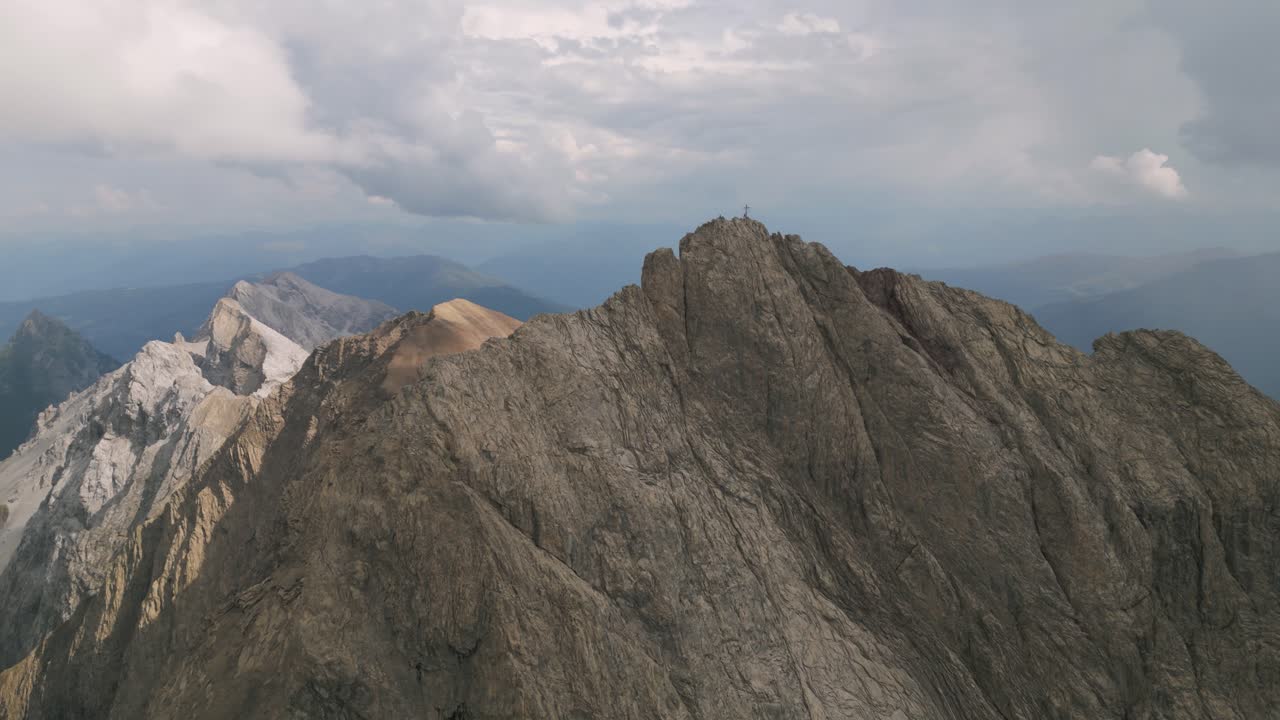 Aerial view of steep mountain peaks under dramatic clouds