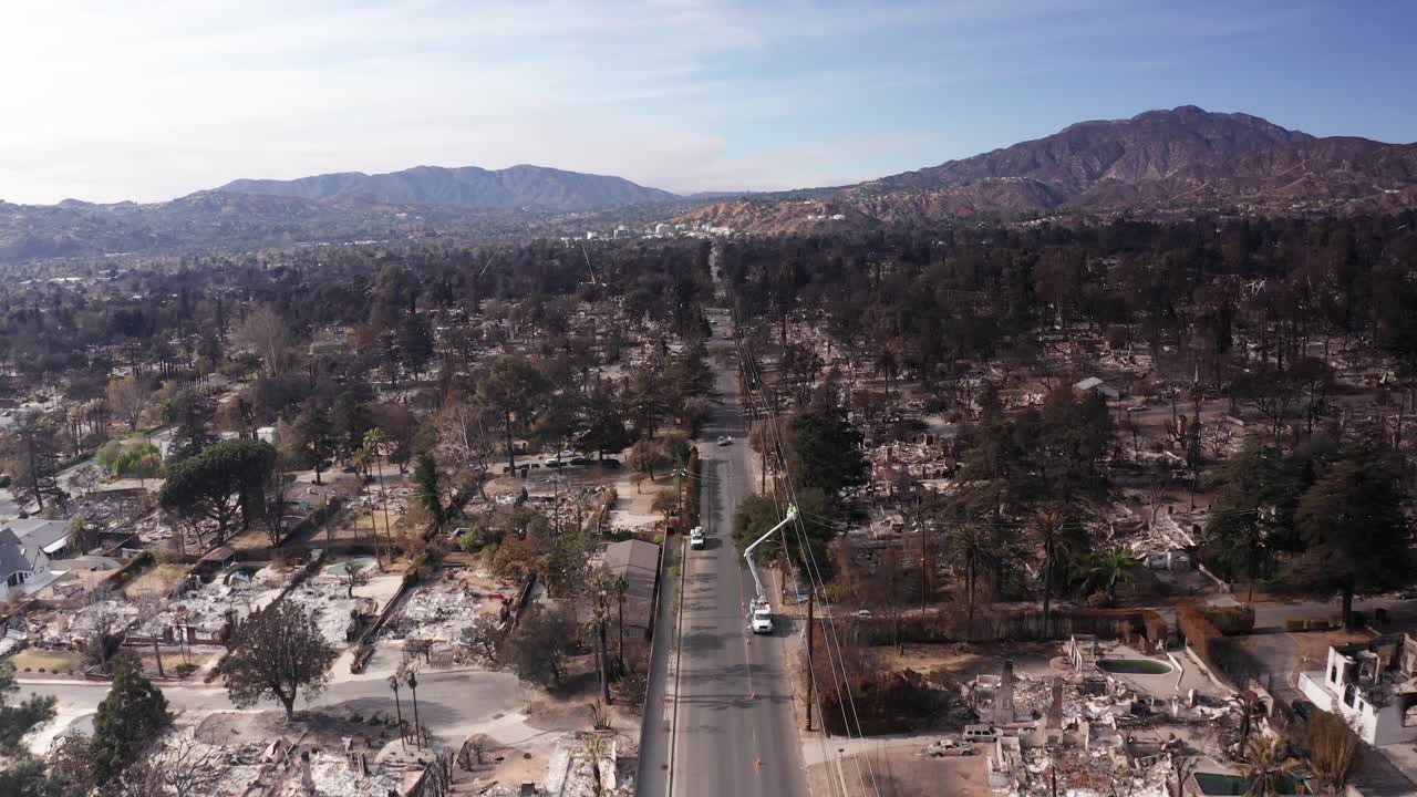 Low aerial shot flying over the devastated landscape along Altadena Drive in the Eaton Canyon wildfire burn scar in Southern California. 4K