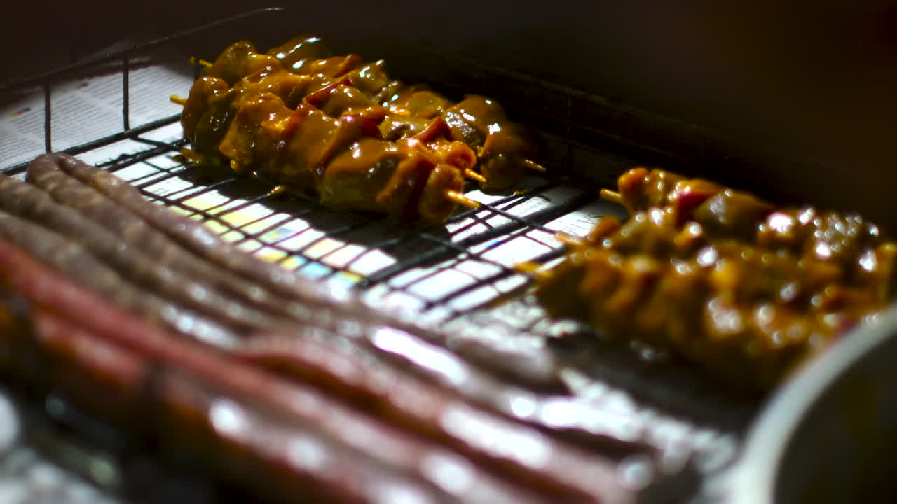 Meat skewers and South African sausage placed in grid for traditional barbecue
